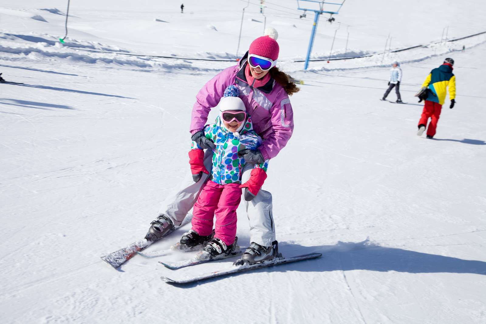 Une maman qui apprend à skier à son enfant