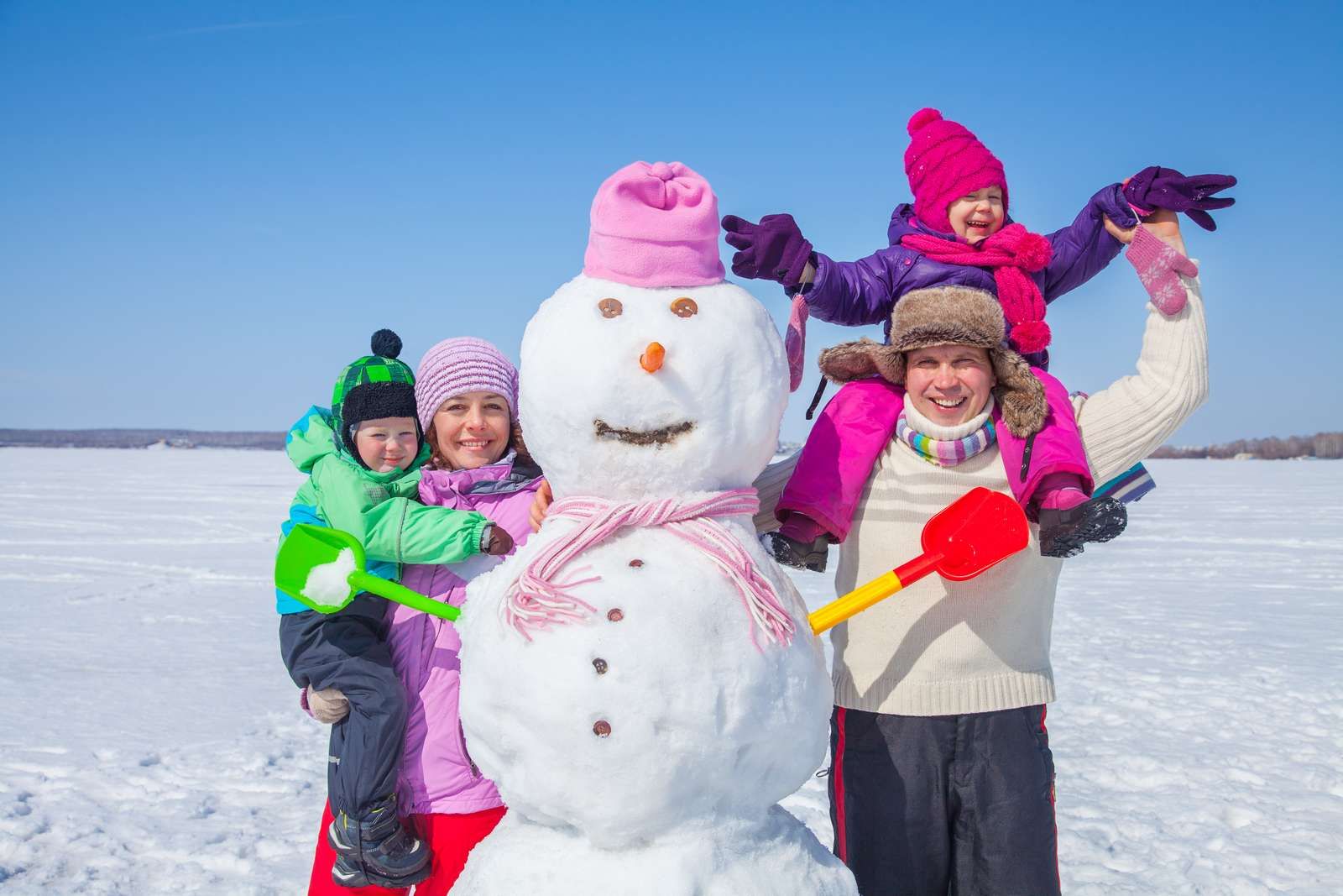 Famille autour d'un bonhomme de neige