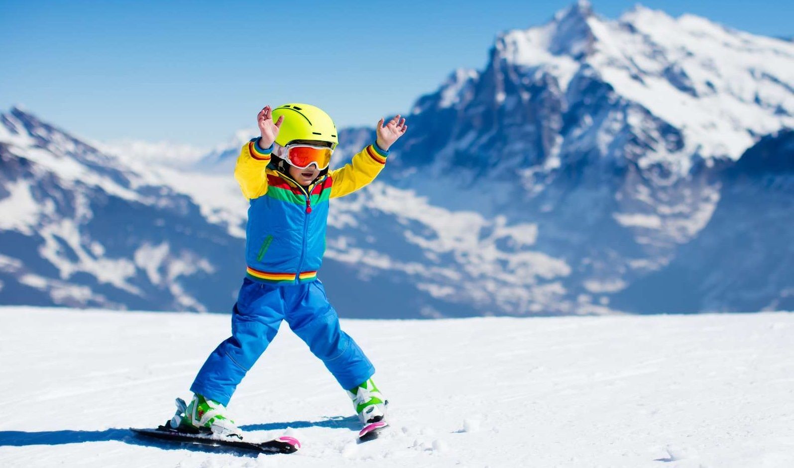 enfant en chasse neige sur une piste de ski